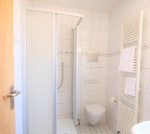 a white bathroom with a toilet and a shower at Gasthof Lamm in Beilstein