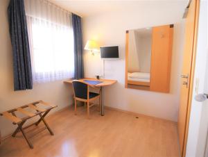 a room with a desk and a chair and a mirror at Gasthof Lamm in Beilstein