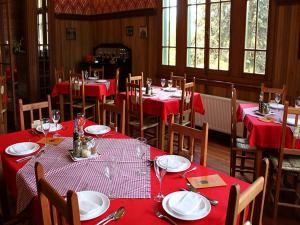 una sala da pranzo con tavoli e sedie rossi e tovaglia rossa di Hotel San Giorgio a Capitán Pastene