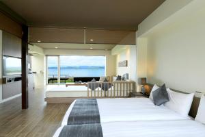 a bedroom with a bed and a view of the ocean at Haimurubushi in Kohama