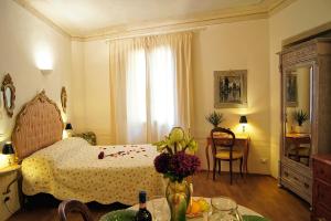 Un dormitorio con una cama y una mesa con flores. en Melarancio Apartments, en Florencia
