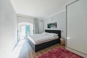 um quarto com uma cama e uma parede de vidro em Smile Apartments zum Goldenen Strauß em Dürnstein