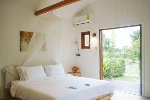 una camera con un letto e una grande finestra di Terrua Main Ten Villa Garden a Suan Phung