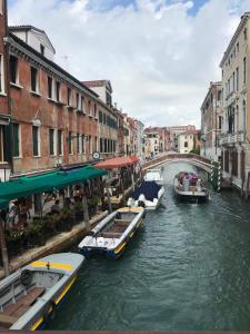 un grupo de barcos en un canal en una ciudad en Blu Suite en Venecia