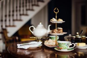 a table with a tea set with pastries and tea cups at Tom Blake House in Kells