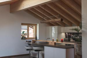 a kitchen with a black counter and stools at Joe's Place - luxury lifestyle apartment in Zermatt