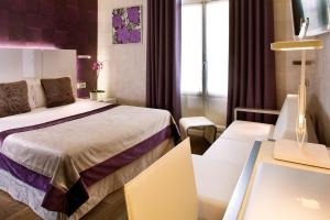 Voodi või voodid majutusasutuse Hotel des Arceaux toas