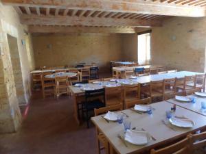 Auberge de Jeunesse HI Cadouin في Le Buisson de Cadouin: غرفة طعام فارغة مع طاولات وكراسي