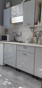 a kitchen with white cabinets and a sink at Apartment on Soborna 91 in Vinnytsya
