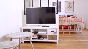 a white entertainment center with a flat screen tv at Central Narbonne with rooftop terrace in Narbonne