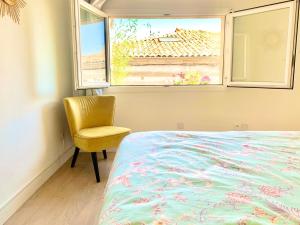 a bedroom with a bed and a chair and a window at Central Narbonne with rooftop terrace in Narbonne