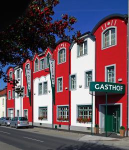 una fila de edificios rojos y blancos en una calle en Hotel Restaurant Wallner I contactless check-in, en Sankt Valentin