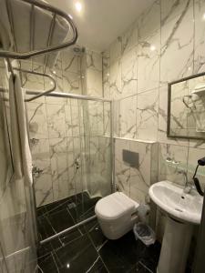 Un baño con ducha, inodoro y lavabo. en Siesta Premium Hotel, en Estambul 108 fotos más