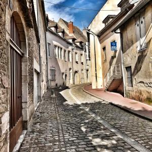 een lege straat in een oude stad met gebouwen bij Grand Cru, Appartement au Centre Médiéval de Beaune in Beaune