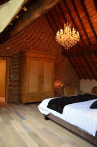 a bedroom with a large bed and a chandelier at B&B N°5 in Liège