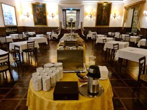 uma sala de jantar com mesas e cadeiras e mesas brancas em Hotel Urgeirica em Nelas
