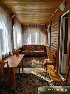 a living room with a couch and a table and chairs at Котедж ,,ТІК" in Tatariv