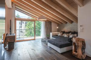 Cette grande chambre comprend un lit et une grande fenêtre. dans l'établissement Joe's Place - luxury lifestyle apartment, à Zermatt