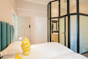 1 dormitorio con 2 camas y espejo en Eendracht Apartments, en Stellenbosch