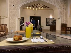 a table with a plate of food and a drink at Smiles Stone Town Hotel in Zanzibar City