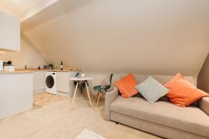 a living room with a couch and a kitchen at Victoria Apartments Tamworth in Tamworth