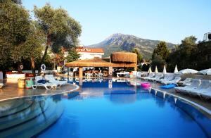 a pool with a pool table and chairs in it at Pinehill Hotel & Suites in Oludeniz