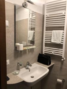 La salle de bains est pourvue d'un lavabo et d'un miroir. dans l'établissement Hotel Nuovo, à Milan