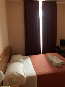una camera da letto con un letto con due asciugamani sopra di Hotel Nuovo a Milano Altre 13 foto