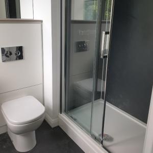 a bathroom with a toilet and a glass shower at The Spires Serviced Apartments Cardiff in Cardiff