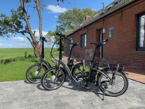 Duas bicicletas estão estacionadas fora de um edifício de tijolos em Fehnhaus an der Kuhweide 45236 em Jemgum