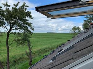 una vista de un campo desde el techo de una casa en Fehnhaus an der Kuhweide 45236, en Jemgum