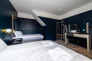 Pokój hotelowy z 2 łóżkami, biurkiem i łóżkiem w obiekcie Hollywood Suite Sasco Apartments w Blackpool