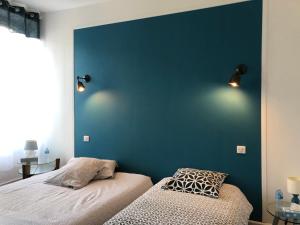 ノジャン・ル・ロトルーにあるLe 42 Chambre bleueの青いアクセントの壁のベッドルーム1室、ベッド1台が備わります。
