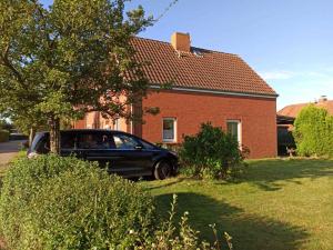 un coche negro estacionado frente a una casa en Ferienhaus Friesenrose 45237 en Ditzum