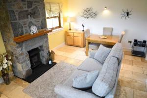 a living room with a couch and a fireplace at Crofters Cottage in Struan
