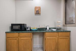 a kitchen counter with a microwave and a bowl of fruit at Rodeway Inn Wormleysburg – Harrisburg in Harrisburg