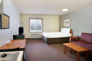 Habitación de hotel con cama y sofá en WoodSpring Suites Cincinnati Fairfield, en Fairfield