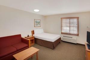 ein Hotelzimmer mit einem Bett und einem Sofa in der Unterkunft WoodSpring Suites Houston I-10 West in Katy