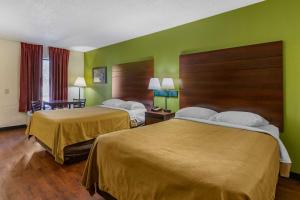 2 camas en una habitación de hotel con paredes verdes en Econo Lodge en Fayetteville