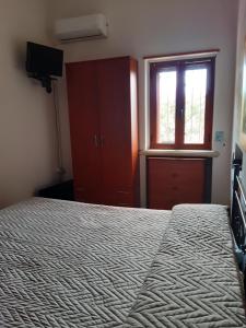 Schlafzimmer mit einem Bett und einem Fenster in der Unterkunft Il Murales Montegiordano in Montegiordano