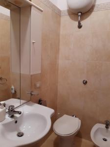 ein Badezimmer mit einem Waschbecken, einem WC und einem Spiegel in der Unterkunft Il Murales Montegiordano in Montegiordano