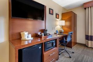 a hotel room with a desk with a large television at Comfort Inn Edgewater on Hudson River in Edgewater