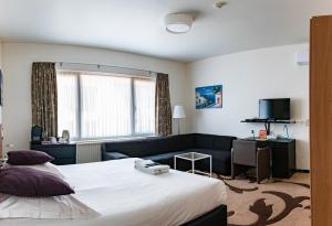een hotelkamer met een bed en een bank bij Hotel Cathedral in Gent