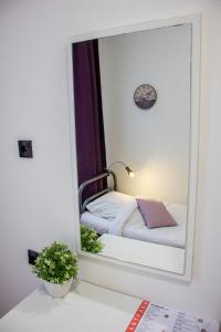 Spiegelreflexion eines Bettes in einem Zimmer in der Unterkunft Simple Seasons Rooms - Самозаселение in Sankt Petersburg