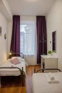 Zimmer mit 2 Betten und einem Fenster mit lila Vorhängen in der Unterkunft Simple Seasons Rooms - Самозаселение in Sankt Petersburg