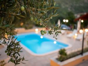 una piscina blu in un cortile con un albero di Apartments Njiric a Zaton