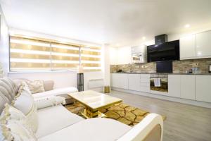 a living room with a white couch and a table at Queen Stay Apartments in Sheffield