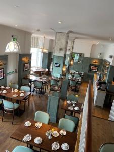 um restaurante com mesas e cadeiras de madeira numa sala em The Beach Hotel em Brighton & Hove