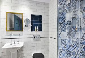 a bathroom with a sink, mirror, and toilet at Hotel Indigo - Stratford Upon Avon, an IHG Hotel in Stratford-upon-Avon