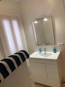 ein Badezimmer mit Waschbecken und Spiegel in der Unterkunft Casa el Pez in Vera